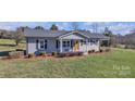 Gray house with a white porch and rocking chairs, green lawn at 2400 Black Oak Ridge Rd, Taylorsville, NC 28681