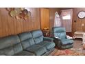 Living room with teal sofas and wood paneled walls at 7614 Secrest Short Cut Rd, Indian Trail, NC 28079