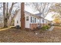 Side view of a white and brick house with a covered entrance, walkway, and landscaping at 3819 Centergrove Rd, Concord, NC 28025