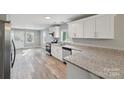 Modern kitchen with white cabinets, granite countertops, and stainless steel appliances at 3819 Centergrove Rd, Concord, NC 28025