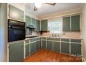 Quaint kitchen with light green cabinets and wood flooring at 961 Shallowbrook Dr, Chester, SC 29706