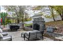 Outdoor patio with stone fireplace, seating area, and grill at 5670 Gold Creek Bay Dr, Hickory, NC 28601