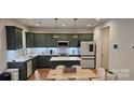 Modern kitchen featuring green shaker cabinets, quartz countertops, and stainless steel appliances at 320 Lawrence Gray Rd, Charlotte, NC 28262