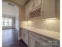 Butler's pantry with white shaker cabinets, quartz countertops, and wine rack at 10881 Greenvale Dr, Harrisburg, NC 28075