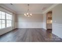 Elegant dining room with hardwood floors, wainscoting and chandelier at 10881 Greenvale Dr, Harrisburg, NC 28075