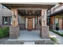 Covered porch entry with brick columns, a wood door, and stylish light fixtures at 339 East Blvd, Charlotte, NC 28203