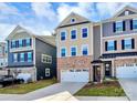 Tan three-story townhome with white garage doors and landscaping at 303 Grove Gate Ln, Indian Trail, NC 28079