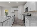 Modern kitchen with white cabinets, granite countertops, and stainless steel appliances at 1403 Gentry Pl, Salisbury, NC 28146