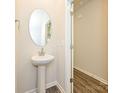 Small bathroom with pedestal sink and oval mirror at 1774 Braemar Village Dr, Monroe, NC 28110