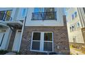 Front exterior of a modern townhome with a balcony and brick facade at 1417 Collier Walk Aly # Csw0207, Charlotte, NC 28205