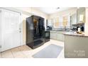 Kitchen features light green cabinets, granite countertops, and a black refrigerator at 3635 Tryon Courthouse Rd, Cherryville, NC 28021