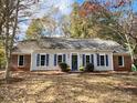 Ranch home with gray siding, blue shutters, and landscaping at 8444 Knollbrook Dr, Charlotte, NC 28270