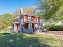 Charming two-story red house with a green lawn at 1411 Lineberger Ave, Gastonia, NC 28052