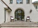 Elegant front entry with arched metal door and brick steps at 1401 Heather Ln, Charlotte, NC 28209