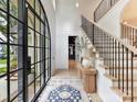 Bright and spacious entryway with a grand staircase and arched windows at 1401 Heather Ln, Charlotte, NC 28209
