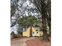 Back exterior of yellow farmhouse with large trees at 1475 Lillys Bridge Rd, Mount Gilead, NC 27306