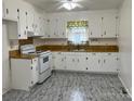 Bright kitchen featuring white cabinets and laminate flooring at 1221 Dogwood Ln, Chester, SC 29706