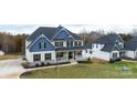 Aerial view of a two-story house with a wrap-around porch and landscaped yard at 6826 Forney Hill Rd, Denver, NC 28037