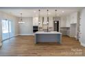 Open concept kitchen with island, white cabinets, and gray lower cabinets at 1865 Rock Hill Church Rd # 3, Matthews, NC 28104