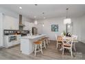 Modern kitchen with white cabinets, island, and dining area at 4147 Merlane Dr, Charlotte, NC 28206