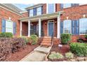 Grand entrance with brick facade and a covered porch at 16404 Grassy Creek Dr, Huntersville, NC 28078