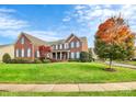 Brick two-story home with manicured lawn and landscaping at 16404 Grassy Creek Dr, Huntersville, NC 28078