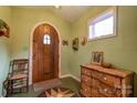 Inviting entryway with arched wood door, hardwood floors and antique furniture at 2224 Taylor Rd, Shelby, NC 28152
