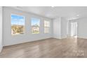 Bright bedroom with three large windows, light wood floors, and a hallway at 183 Sugar Hill Rd, Troutman, NC 28166