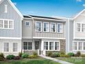 Two-story townhome with gray siding, stone accents, and a landscaped front yard at 5676 Clear Creek Ln, Charlotte, NC 28215