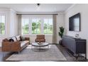 Cozy living room with leather sofa, large window, and media console at 5676 Clear Creek Ln, Charlotte, NC 28215