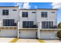 Rear view of three-unit townhouse building, showcasing garages and balconies at 659 District Ct # 20, Fort Mill, SC 29708