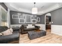 Living room with gray walls, leather sofas, and decorative picture frames at 2101 Darian Way, Waxhaw, NC 28173