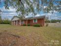 Brick ranch house with covered porch and mature trees at 3113 Old Pageland Marshville Rd, Wingate, NC 28174