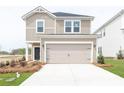 Tan two-story house with black door and two-car garage at 913 Smithcliffs Trl, York, SC 29745