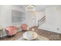 Elegant living room featuring pink velvet chairs and a glass coffee table at 1628 Savory Ln, Charlotte, NC 28216