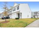 Townhome with white siding, stone accents, and a grassy yard at 10002 Brittondale Ln, Charlotte, NC 28215