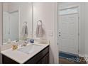 Clean and modern powder room with dark vanity and white sink at 208 Waterlynn Ridge Rd # B, Mooresville, NC 28117