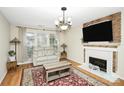 Living room featuring a fireplace, hardwood floors, and comfortable seating at 1846 Colin Creek Ln, Charlotte, NC 28214