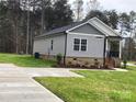 Gray sided home with brick base and side yard at 3010 Forbes Rd, Gastonia, NC 28056