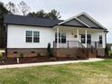 Newly built home with gray and white exterior, front porch, and landscaped yard at 3008 Forbes Rd, Gastonia, NC 28056