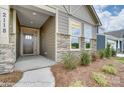 Front porch entryway with stone accents and a charming, dark brown door at 4025 Grace Pointe Dr # 105, Wesley Chapel, NC 28079