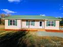 Beige house with green roof, covered porch, and landscaped yard at 2172 Robert Usher Rd, Lancaster, SC 29720