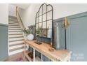 Entryway with wooden console table, mirror, and staircase at 318 Simeon Dr, Charlotte, NC 28208