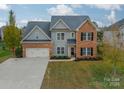 Two-story brick home with a two-car garage and landscaped yard at 10126 Loch Lomond Dr, Charlotte, NC 28278