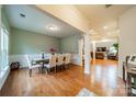 Formal dining room with hardwood floors, a large table, and access to living room at 10126 Loch Lomond Dr, Charlotte, NC 28278