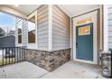 Front entry with a teal door, stone base, and a covered porch at 14415 Autumncrest Rd # 2, Huntersville, NC 28078