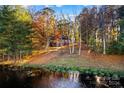 House nestled on a waterfront lot with autumn foliage at 169 Rimmer Farm Rd, Troutman, NC 28166