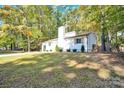 White house exterior, nestled among lush green trees, showcasing curb appeal at 11116 Vista Canyon Dr, Charlotte, NC 28226