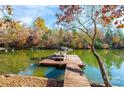 Private wooden dock on the lake with a pontoon boat at 115 Charlotte Ann Ln, Hickory, NC 28601