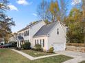 Two-story house with beige siding, dark shutters, and a side view of the home at 12202 Shiro Ct, Huntersville, NC 28078